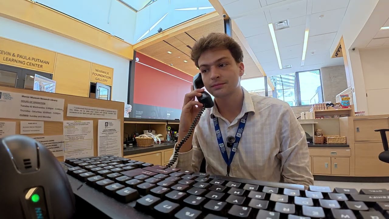 Video still: Reese answering the phone at the Mercer Museum front desk