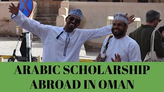 Video still: Reese with two men in Omani dress, captioned Arabic Scholarship Abroad in Oman