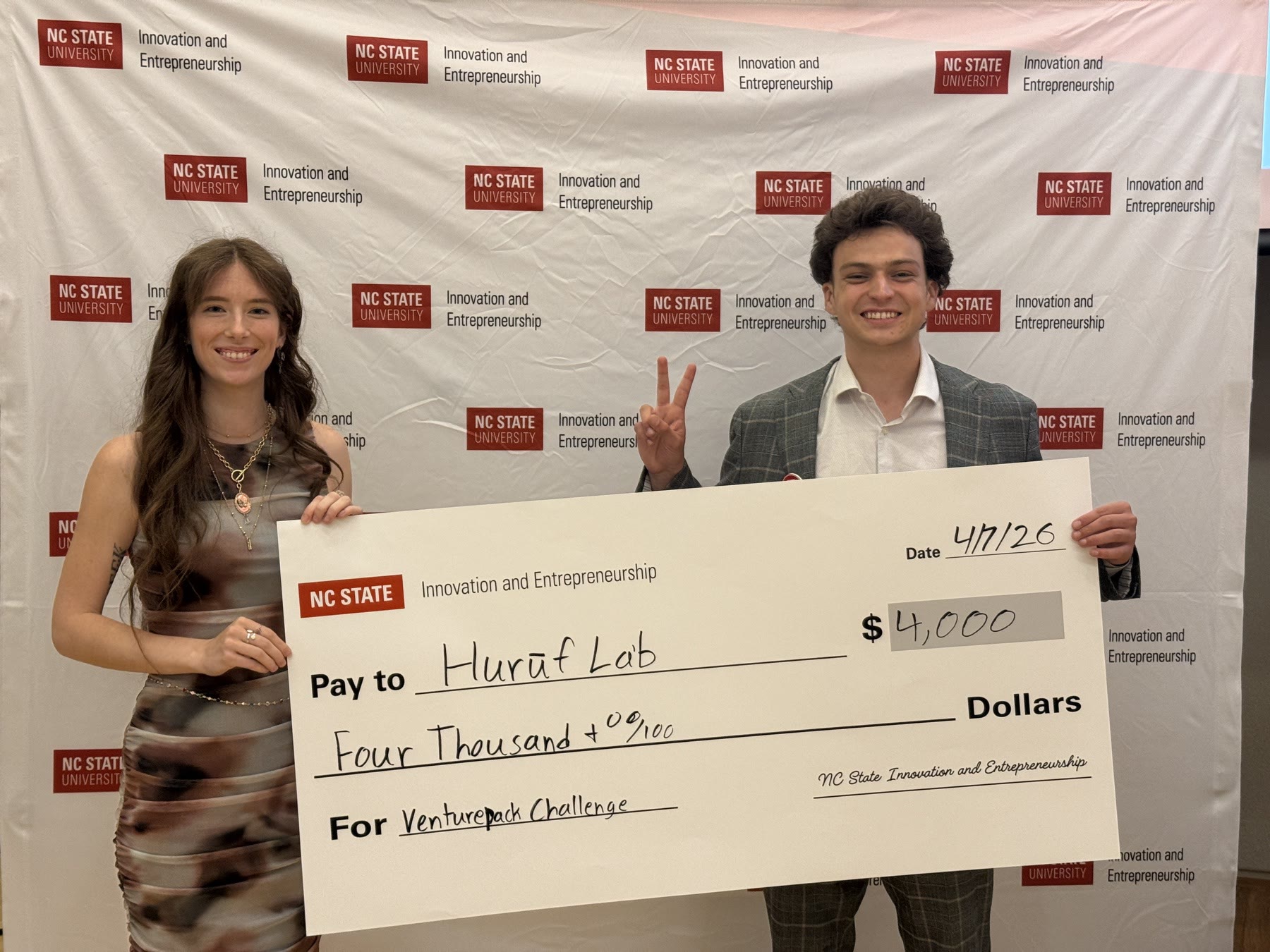 Reese Hollister and his co-founder holding an oversized $4,000 check made out to Huruf Lab, winners of the NC State VenturePack Challenge.