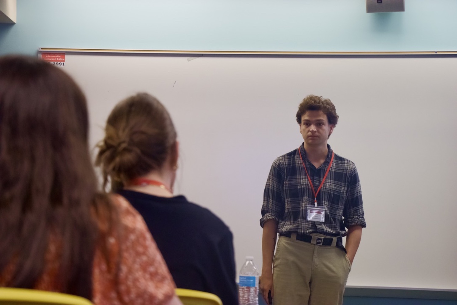 Reese teaching at the front of a classroom, presenting to seated students.